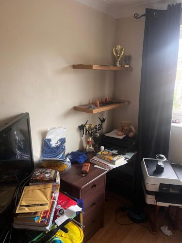 a cluttered room with a desk and a television at No name 