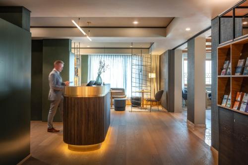 a man standing at a counter in a room at Hotel Maier in Friedrichshafen