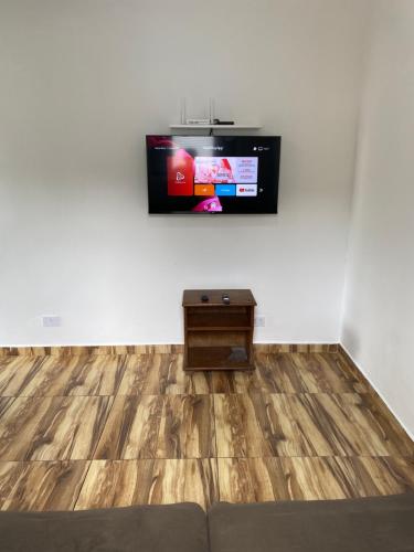 a living room with a tv on a white wall at Casa mirante Bela Vista in Guarujá