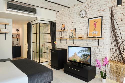 a bedroom with a tv and a brick wall at Magnova Studios in Istanbul