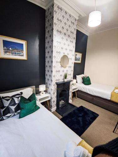 a bedroom with two beds and a fireplace at A&A Luxury Stay Eldon Street in Pallion