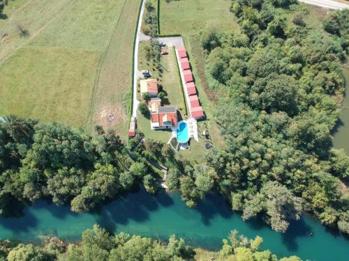 DanilovgradにあるSeosko domaćinstvo Jovanovićの家と湖のある農場の空中風景