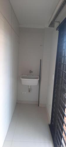 a bathroom with a sink in a white wall at VS HOSPEDAGEM in Cascavel