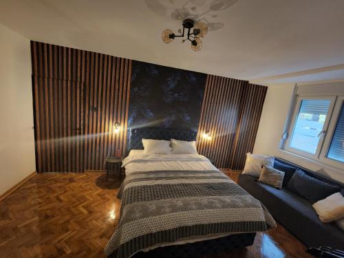 a bedroom with a bed and a couch at Nancy's Cozy Business Apartment in Bežanija