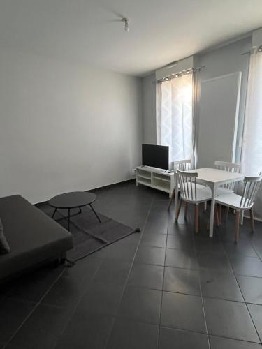 un salon avec une table, des chaises et un canapé dans l'établissement Appartement gare RER D maisons alfort Alfortville, à Alfortville