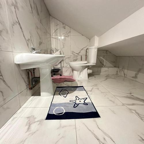 La salle de bains est pourvue d'un lavabo et d'un tapis étoilé. dans l'établissement Galaxy Houses - Charmante maison de vacances, à Vitry-sur-Seine