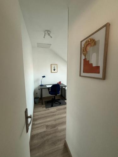 a hallway with a desk and a chair in a room at RêvAppart in Haveluy