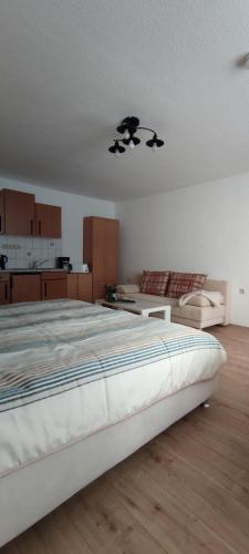 a bedroom with a large bed and a kitchen at Ferienwohnung Schulzental in Ilmenau