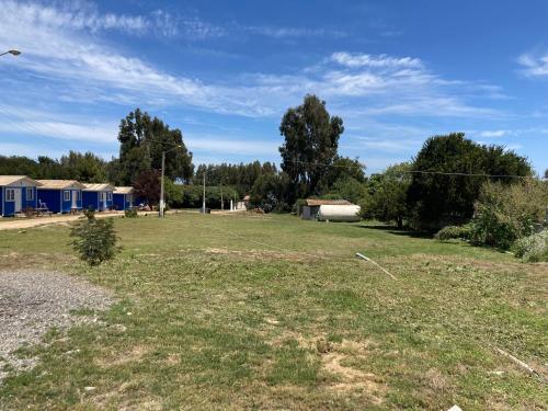 un gran campo de césped con casas en el fondo en Cabañas San Carlos, en Las Cruces