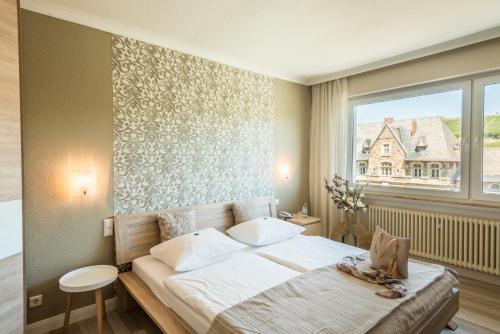 a bedroom with a bed and a large window at Hotel Ahrbella in Bad Neuenahr-Ahrweiler
