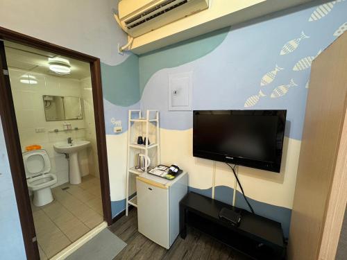 La salle de bains est pourvue de toilettes et d'une télévision murale. dans l'établissement Yi Chung Disney, à Taichung
