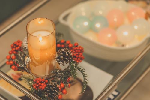 a candle on a glass table with christmas decorations at Ocean Marina Suite View in Yeosu
