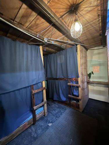 a room with two bunk beds and a blue curtain at SASY Dorm in Santa Catalina