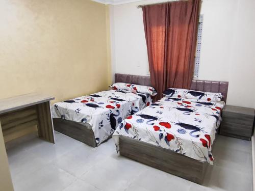 a bedroom with two twin beds and a window at Gardenia compound in Cairo