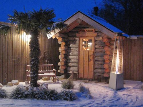 une cabane en rondins avec banc dans la neige dans l'établissement Hotel Dolores Ameland, à Hollum