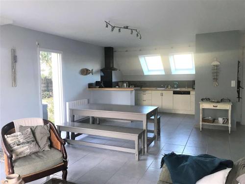un salon avec une table et une cuisine dans l'établissement Maison 5P à Quiberon, 130m², proche plage, terrasse sud, jardin, garage, accepte animaux - FR-1-478-12, à Quiberon