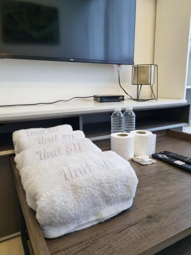 マニラにあるQE811 Cozy 1 BR & Sofa Bed Free WiFi & Pool Accessのテレビのあるテーブルの上に置かれた枕
