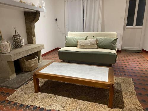 a living room with a couch and a coffee table at La petite maison de Coline in Réville