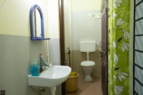 La salle de bains est pourvue d'un lavabo et de toilettes. dans l'établissement Reunion Amity, à Udupi