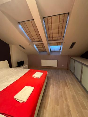 ein Schlafzimmer mit einem roten Bett mit zwei Handtüchern darauf in der Unterkunft Apartment on Arkhipenka with Panorama View in Lwiw