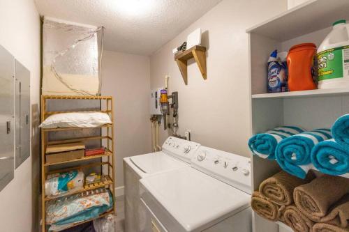 a laundry room with a washing machine and a shelf at NEW Stylish & Cozy Dune Daisy near Beach & Flagler in New Smyrna Beach