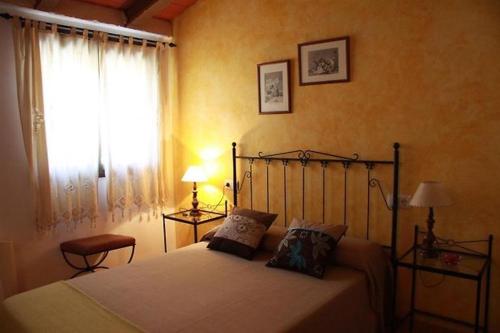 a bedroom with a bed and a window at La Tellería in Valjunquera