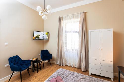 - une chambre avec un lit et deux chaises bleues dans l'établissement ESTER'S Szentbékkálla, à Szentbékkálla