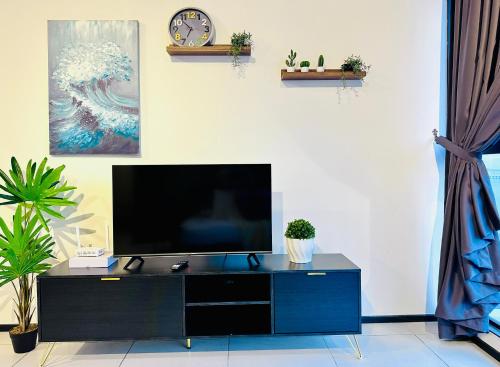 a living room with a tv on a blue cabinet at New 2BR or 3BR Cozy Urban Suite Homestay at Georgetown8-10pax by URBAN STAYCATIONS LOD in Jelutong