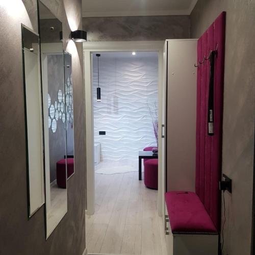 einen Flur mit Tür zu einem Bad mit roten Vorhängen in der Unterkunft VIP квартиры 07 in Oral
