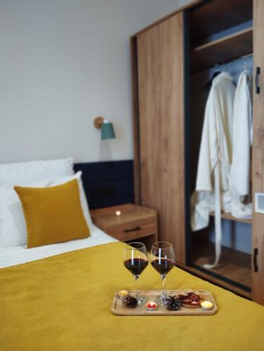 two glasses of wine on a tray on a bed at Arevaham Boutique Hotel in Stepʼanavan