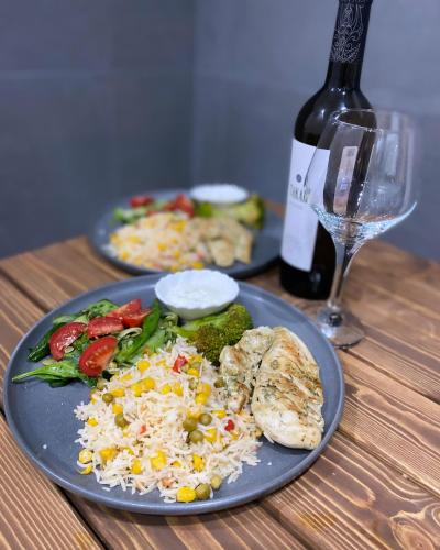 a table with two plates of food and a bottle of wine at Arevaham Boutique Hotel in Stepʼanavan