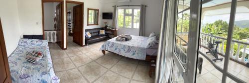 a living room with a bed and a balcony at Royal Bay Villa and Apartment in Anse Royale
