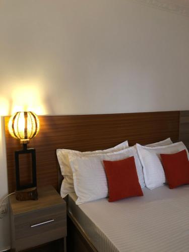 Schlafzimmer mit einem Bett mit roten und weißen Kissen in der Unterkunft Savwa Resort and Gardens in Kakamega