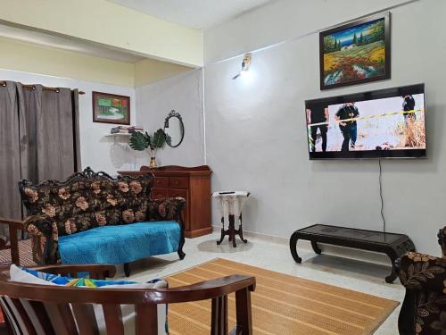a living room with a couch and a flat screen tv at OneB Homestay Shah Alam in Shah Alam