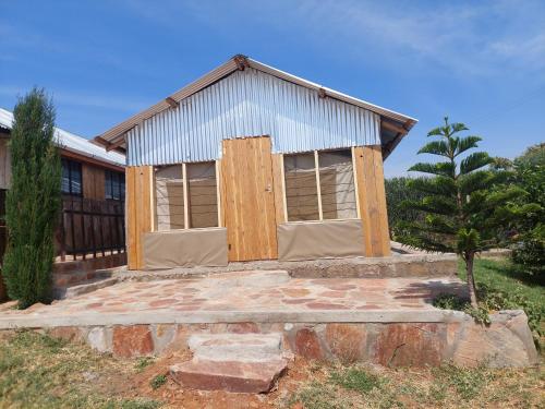 a building with boarded up windows and a tree at KANUNKA HOUSE in Sekenani