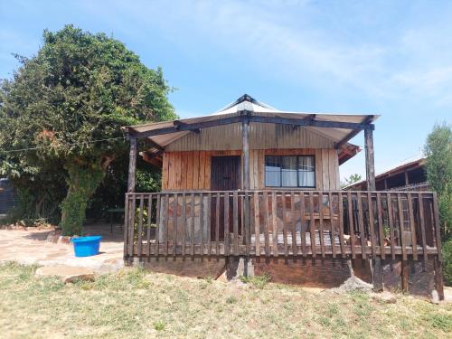 a small wooden house with a porch at KANUNKA HOUSE in Sekenani