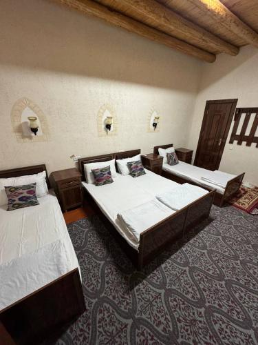 a room with three beds in a room at Art House Boutique Hotel in Khiva