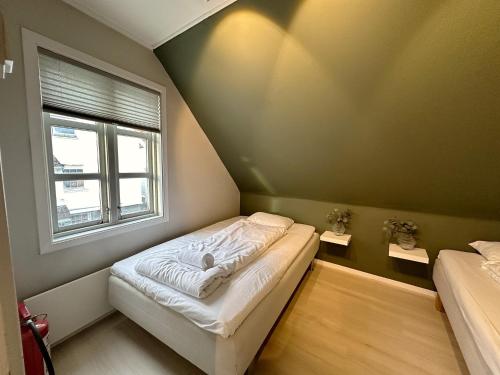 a small bedroom with a bed and a window at The Green Door H3 in Stavanger