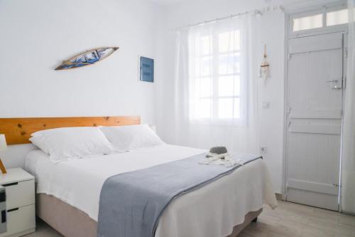 a white bedroom with a large bed and a window at Blue Sea House in Klima