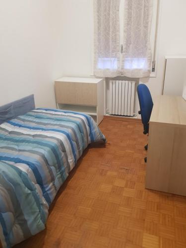 伊莫拉的住宿－Casa frà i Pini，一间卧室配有一张床、一张桌子和一把椅子