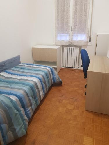 Un dormitorio con una cama, un escritorio y una silla. en Casa frà i Pini, en Imola