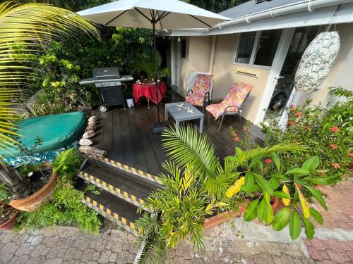 a patio with two chairs and an umbrella at Royal Bay Villa and Apartment in Anse Royale