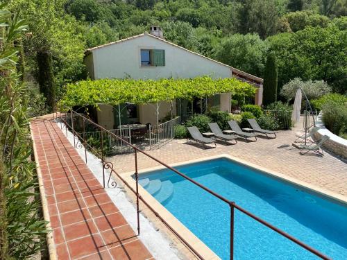 eine Villa mit einem Pool und einem Haus in der Unterkunft Les Dentelles in Beaumes-de-Venise