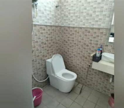 y baño con aseo blanco y lavamanos. en HOMESTAY PETRON CABANG 3, en Pengkalan Cepa