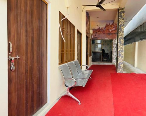 a chair sitting on a red carpet in a hallway at RN Residency in Varanasi