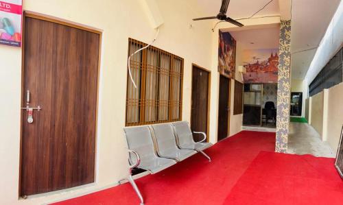a living room with a red carpet and a chair at RN Residency in Varanasi