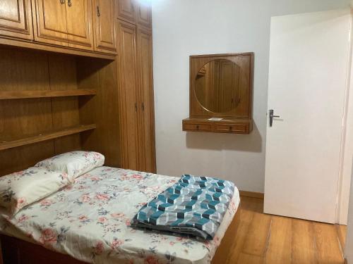 um quarto com uma cama, um armário e uma porta em Apartamento no Hotel Quitandinha 40 em Petrópolis