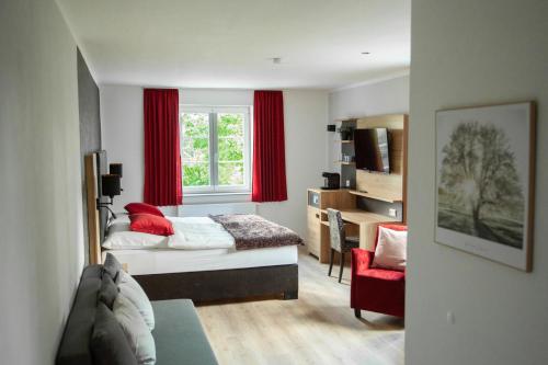 a bedroom with a bed and a window with red curtains at Landgasthof Obersteberg in Sprockhövel