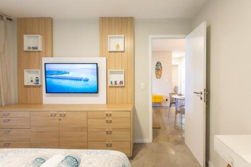 a bedroom with a television on a wooden dresser at Cumbuco Wai Wai Apartamento com vista para o mar in Cumbuco
