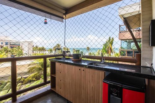 Cumbuco Wai Wai Apartamento com vista para o mar في كومبوكو: مطبخ مع شرفة مطلة على المحيط